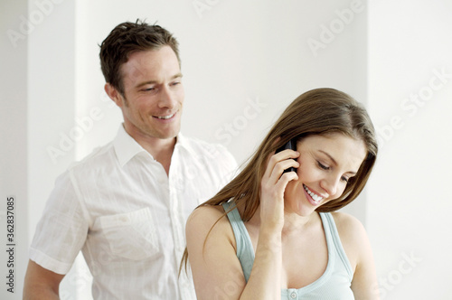 Man watching his girlfriend talking on the phone
