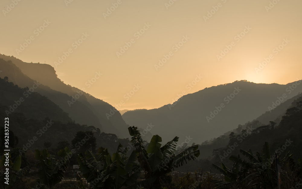 Bright sunset over tree covered mountains, Annapurna circuit, Nepal