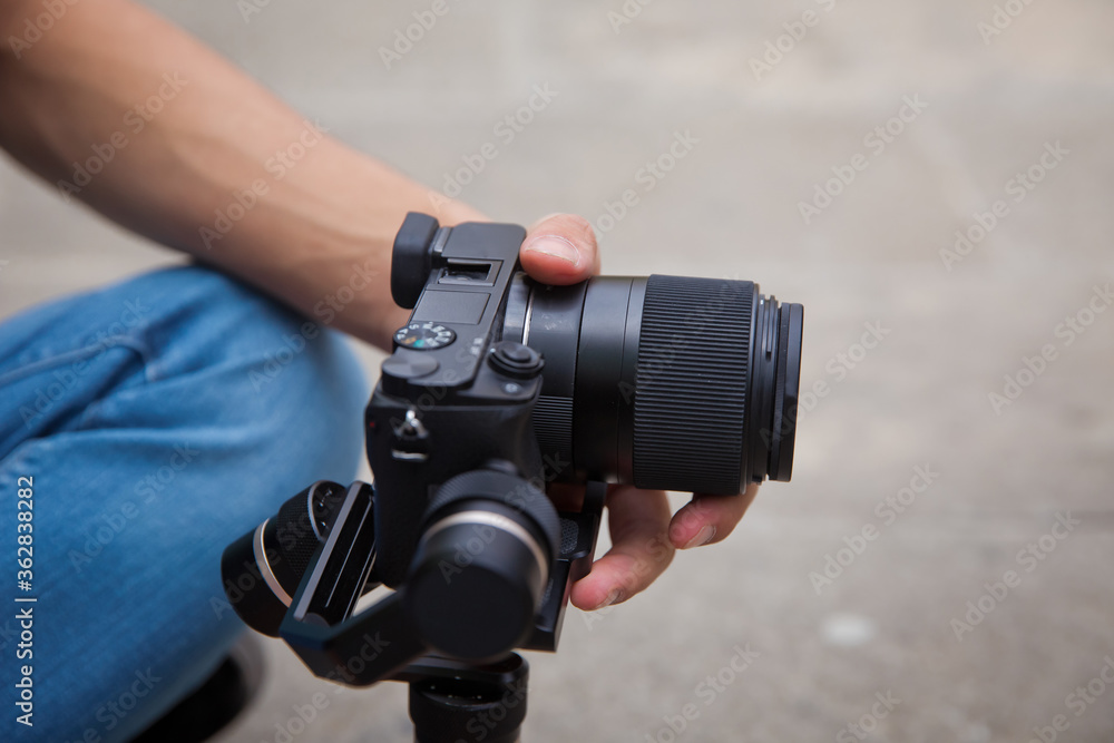 Gimbal Operator with black equipament - Stabilizer and camera filmmaking . An unidentified man holding gimbal a camera stabilizer . Man holding gimbal stabilizer outdoor. Gimbal Operator with black equipament - Stabilizer and camera filmmaking . An unidentified man holding gimbal a camera stabilizer . Man holding gimbal stabilizer outdoor.