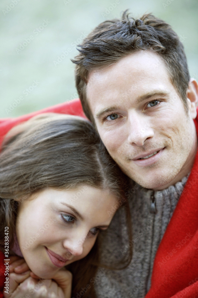 Fototapeta premium Couple covered with red blanket