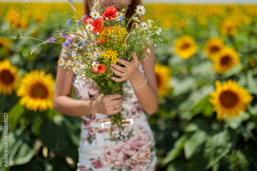 Pretty young woman on a sunflowers field