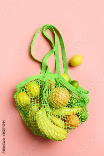 Mesh bag with fruits, lemon, orange. Sustainable lifestyle and reusable bag. Zero waste. Vertical.