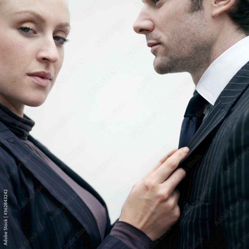 Businessman pulling businessman's suit while staring at the camera Businessman pulling businessman's suit while staring at the camera