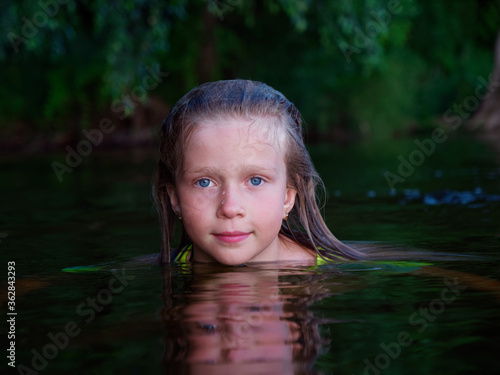Fototapeta Naklejka Na Ścianę i Meble -  mermaid girls with blue eyes and wet hair in dark water