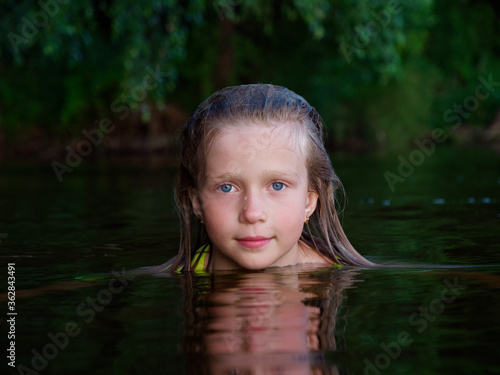 Fototapeta Naklejka Na Ścianę i Meble -  mermaid girls with blue eyes and wet hair in dark water
