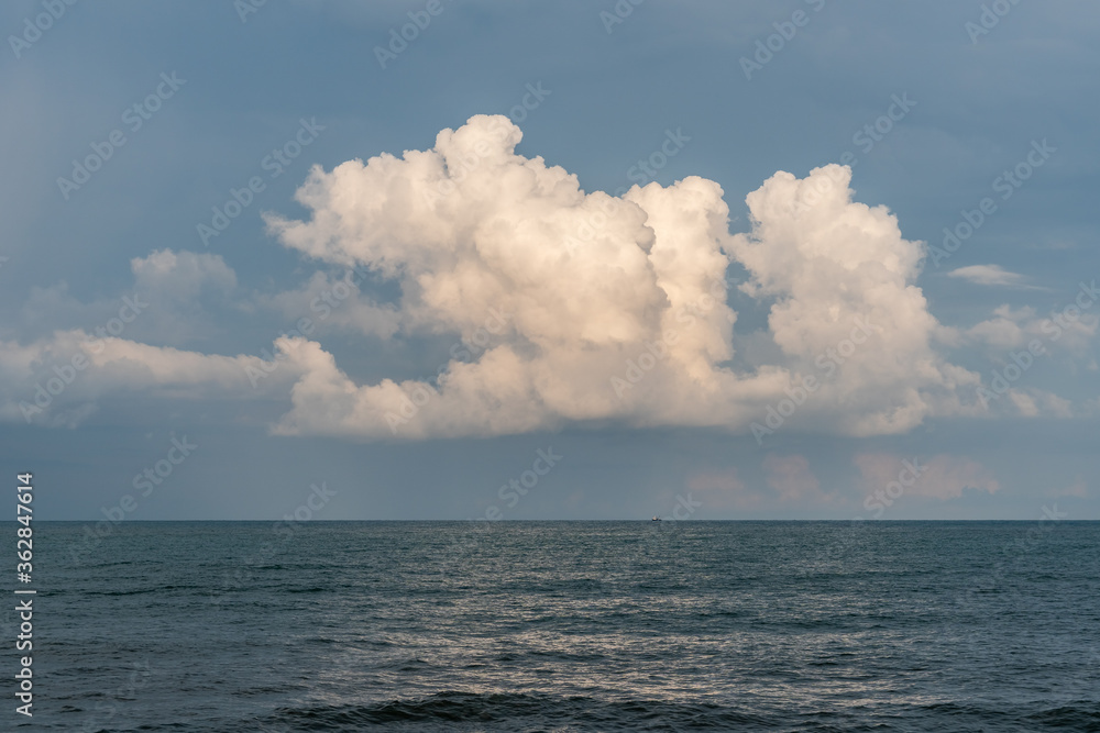 Calm Sea, Black Sea and white clouds on a Blue Sky Background