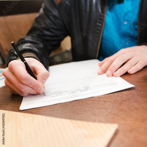 Obraz na płótnie A man fills out a document form. Hands close-up w salonie
