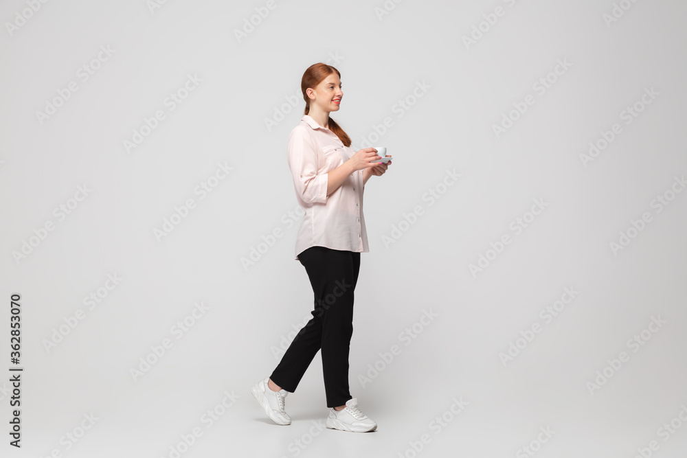 Coffee time. Young woman in casual wear on white background. Bodypositive character, feminism, loving herself, beauty concept. Plus size businesswoman during paperwork. Inclusion, diversity. Coffee time. Young woman in casual wear on white background. Bodypositive character, feminism, loving herself, beauty concept. Plus size businesswoman during paperwork. Inclusion, diversity.