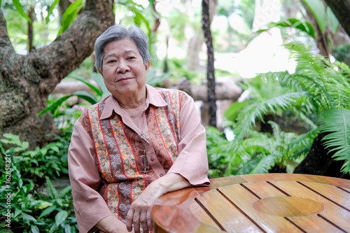 Quadro su tela elder woman resting in garden
