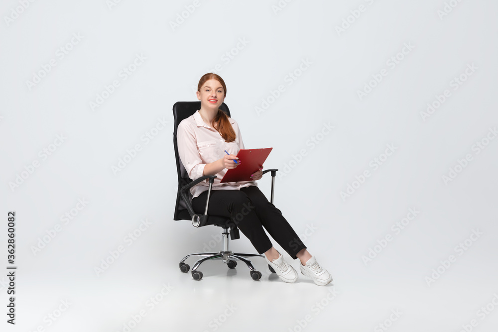 Working with documents. Young woman in casual wear on white background. Bodypositive character, feminism, loving herself, beauty concept. Plus size businesswoman during paperwork. Inclusion, diversity Working with documents. Young woman in casual wear on white background. Bodypositive character, feminism, loving herself, beauty concept. Plus size businesswoman during paperwork. Inclusion, diversity
