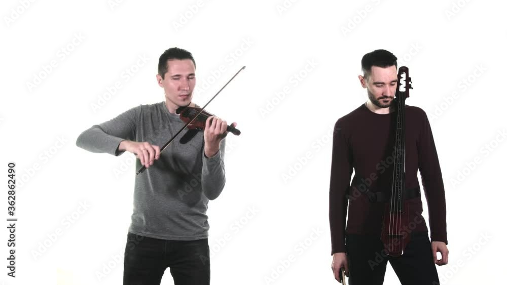 duet of young talented men plays electric violin and electric cello. Isolated. Medium long shot duet of young talented men plays electric violin and electric cello. Isolated. Medium long shot
