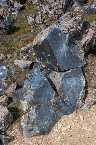 Volcanic glass rock known as obsidian found in lava fields formed by polymerized magma during volcanic eruption in rhyolitic silica, Iceland photo