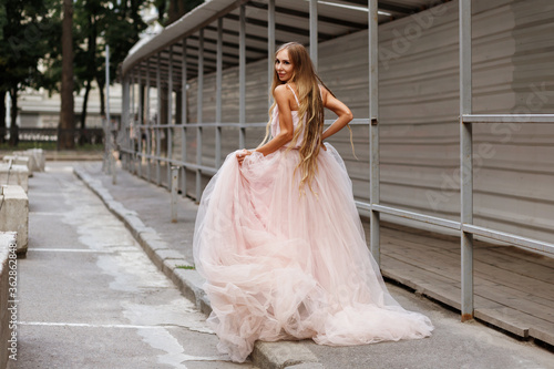 Bride in pink wedding dress runs off street town