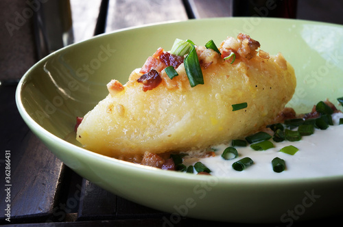 Cepelinai (zeppelin) with sour cream, cracklings and and green onion. photo