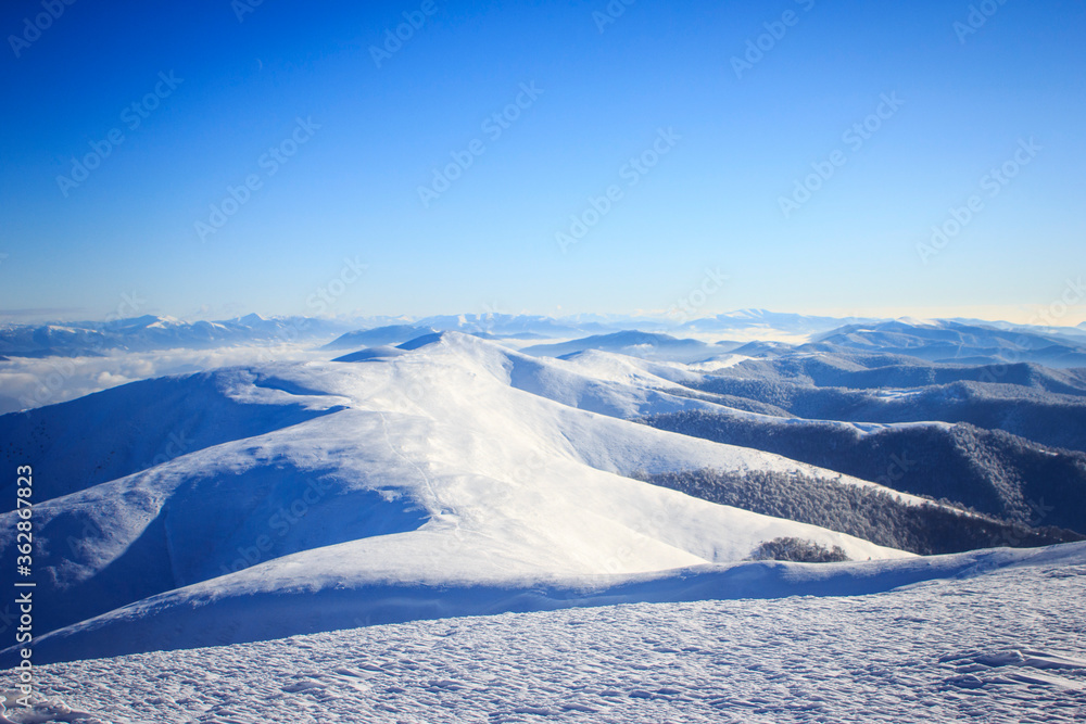 A man flying through the air on a snow covered mountain