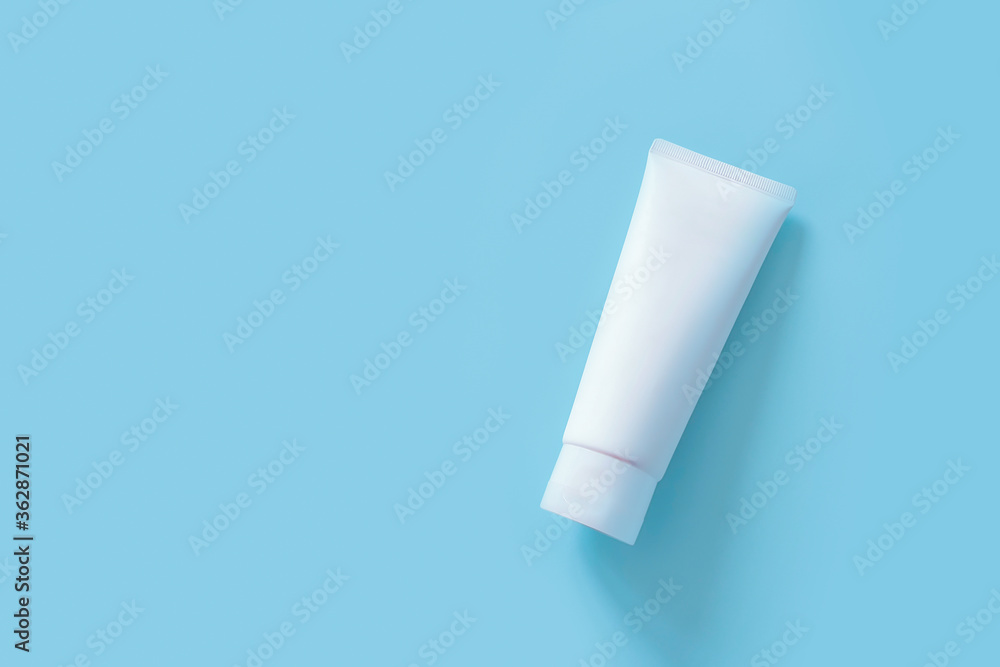 Cosmetic bottle container on a pastel blue background. Top view of mockup of white squeeze bottle plastic tube for branding of medicine or cosmetics - cream, gel, skin care, toothpaste. Minimalism Cosmetic bottle container on a pastel blue background. Top view of mockup of white squeeze bottle plastic tube for branding of medicine or cosmetics - cream, gel, skin care, toothpaste. Minimalism
