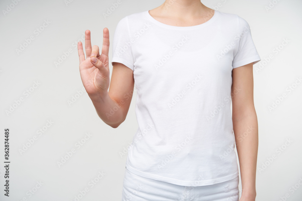 Horizontal photo of young woman raising her hand and pointing up with fingers number eight while standing over white background in basic white t-shirt Horizontal photo of young woman raising her hand and pointing up with fingers number eight while standing over white background in basic white t-shirt
