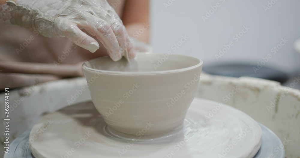 Potter making ceramic pot on the pottery wheel Potter making ceramic pot on the pottery wheel