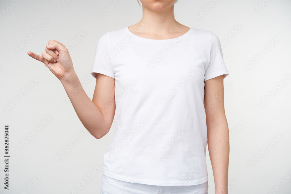 Studio shot of young female raising her hand while expressing thoughts without words, forming letter j with fingers while showing deaf alphabet, isolated over white background Studio shot of young female raising her hand while expressing thoughts without words, forming letter j with fingers while showing deaf alphabet, isolated over white background