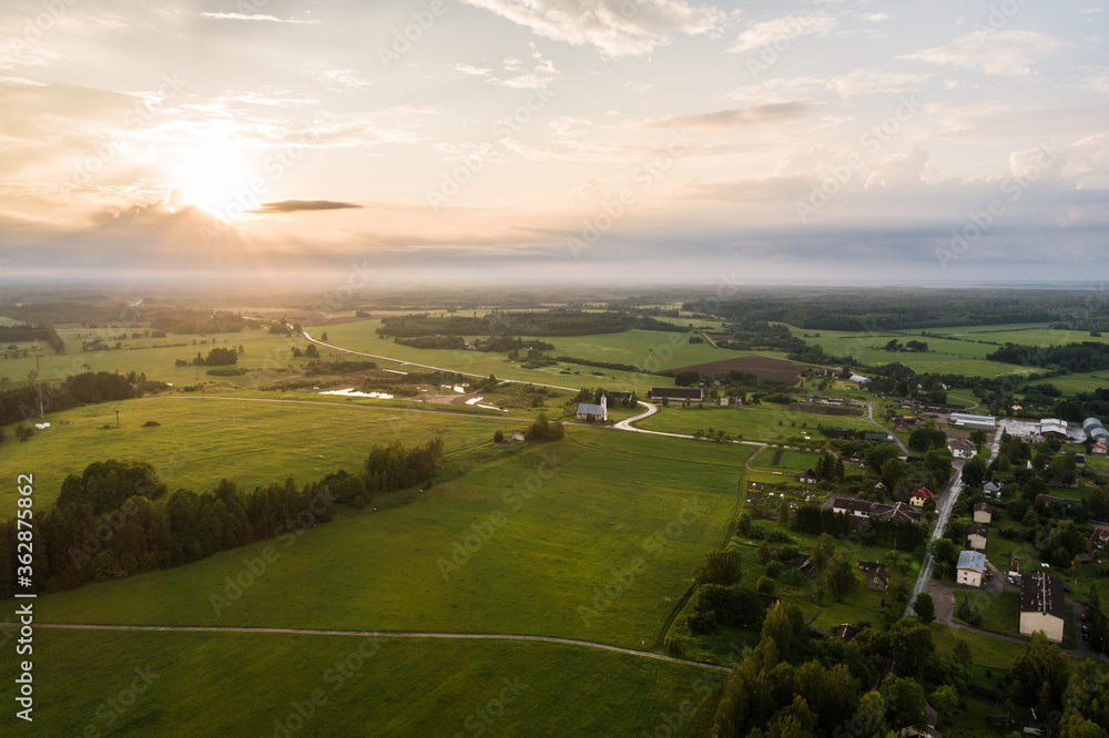 Aerial view. Countryside surrounded by green fields. Small town.