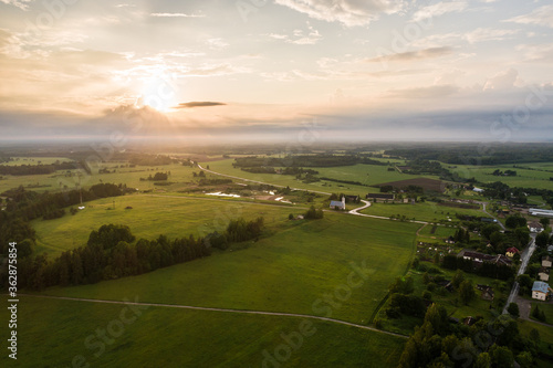 Aerial view. Countryside surrounded by green fields. Small town.