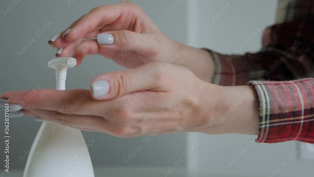 Disinfection, protection, prevention, COVID 19, coronavirus, safety, sanitation concept. Super slow motion: woman pushing dispenser and squeezing out antiseptic gel on palm - close up, selective focus Disinfection, protection, prevention, COVID 19, coronavirus, safety, sanitation concept. Super slow motion: woman pushing dispenser and squeezing out antiseptic gel on palm - close up, selective focus