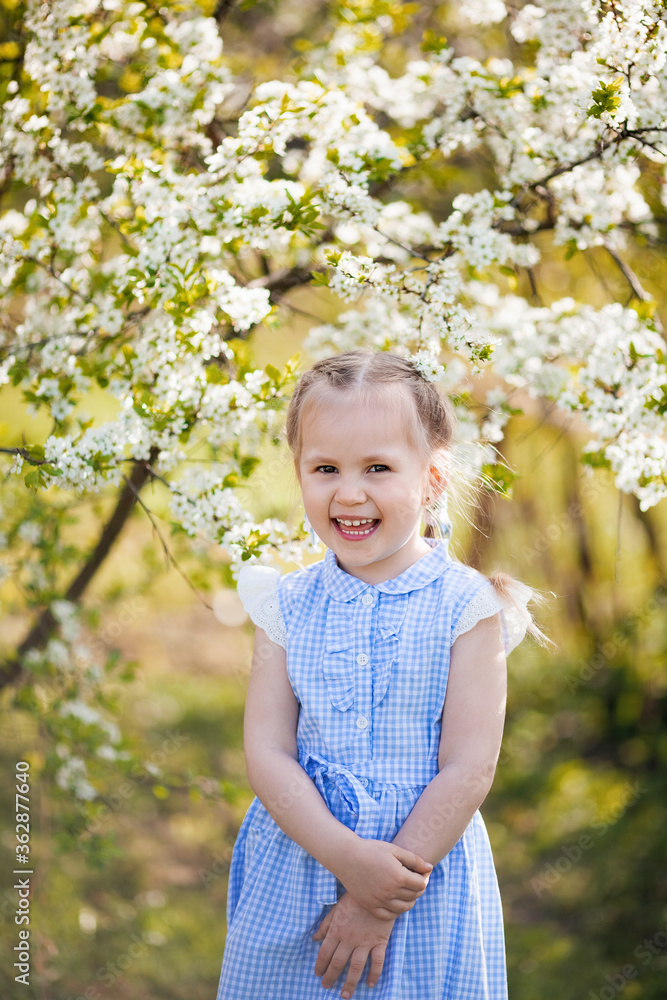 Portrait of beautiful little girl in blooming tree garden on spring day Portrait of beautiful little girl in blooming tree garden on spring day