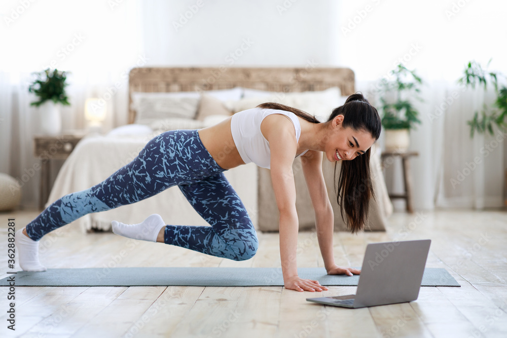 Home Workout. Young Asian Girl Practicing Sport In Front Of Laptop Home Workout. Young Asian Girl Practicing Sport In Front Of Laptop