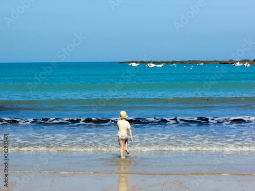 Young tourist boy plays in the water of atlantic ocean on the coast of Cadiz  Andalusia  Spain