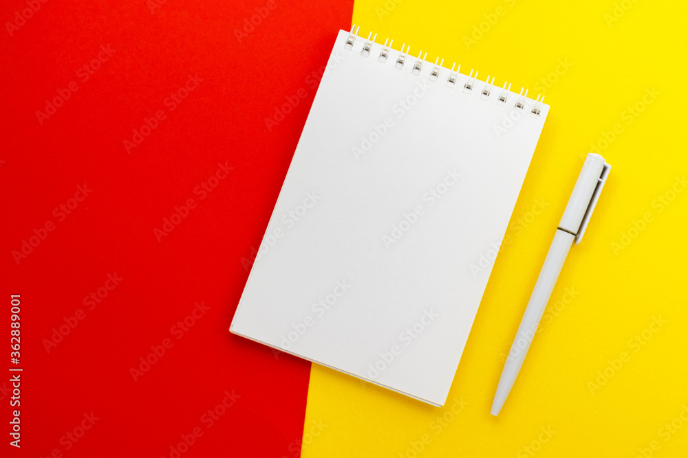 Blank notepad and pen on trendy dark yellow-red background. Notebook for ideas message, list and inspiration. Top view, flat lay with copy space. Mockup for your design. Blank notepad and pen on trendy dark yellow-red background. Notebook for ideas message, list and inspiration. Top view, flat lay with copy space. Mockup for your design.