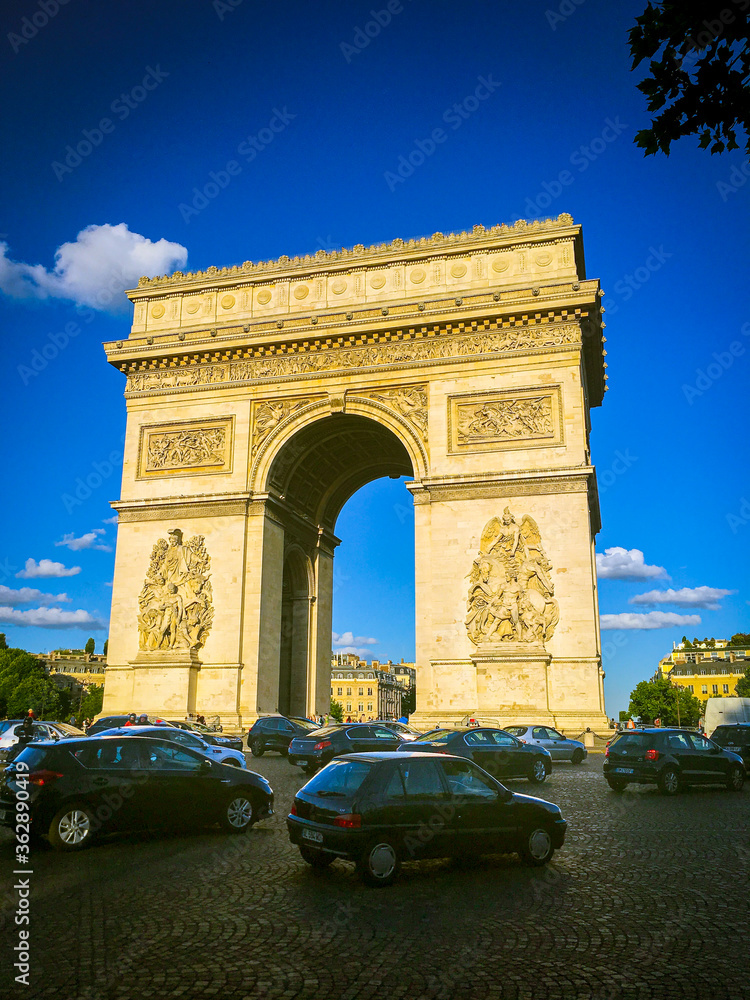 Arc de Triomphe on a sunny day with some traffic below.