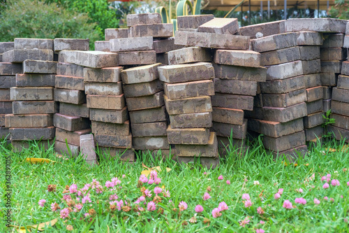 A pile of paving tiles on the field with flowers