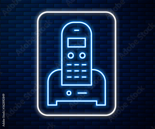 Glowing neon line Telephone icon isolated on brick wall background. Landline phone. Vector Illustration.