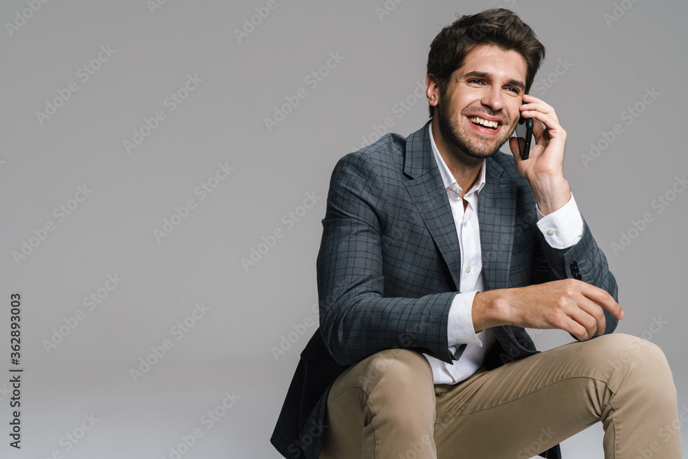 Photo of laughing businessman talking on cellphone while siting Photo of laughing businessman talking on cellphone while siting