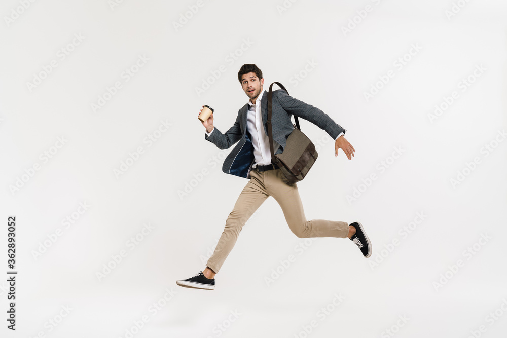 Photo of surprised businessman drinking coffee while running with bag