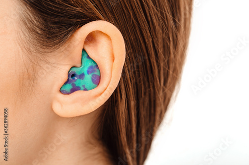 Personally molded earplugs for use in an airplane at high atmospheric pressure with pressure valve. Individual stylish earplugs close-up