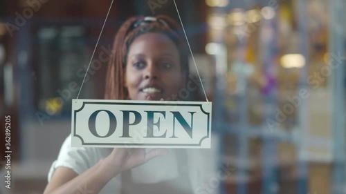 Wallpaper Mural Small business african female owner smiling while turning sign for opening of cafe Torontodigital.ca
