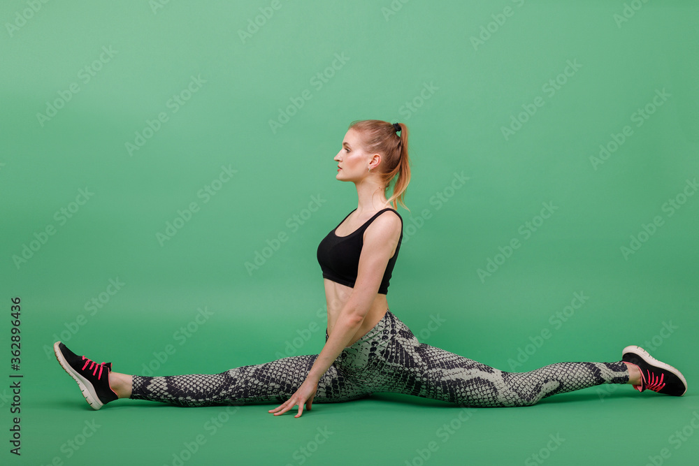 Girl stretches on twine on a green background