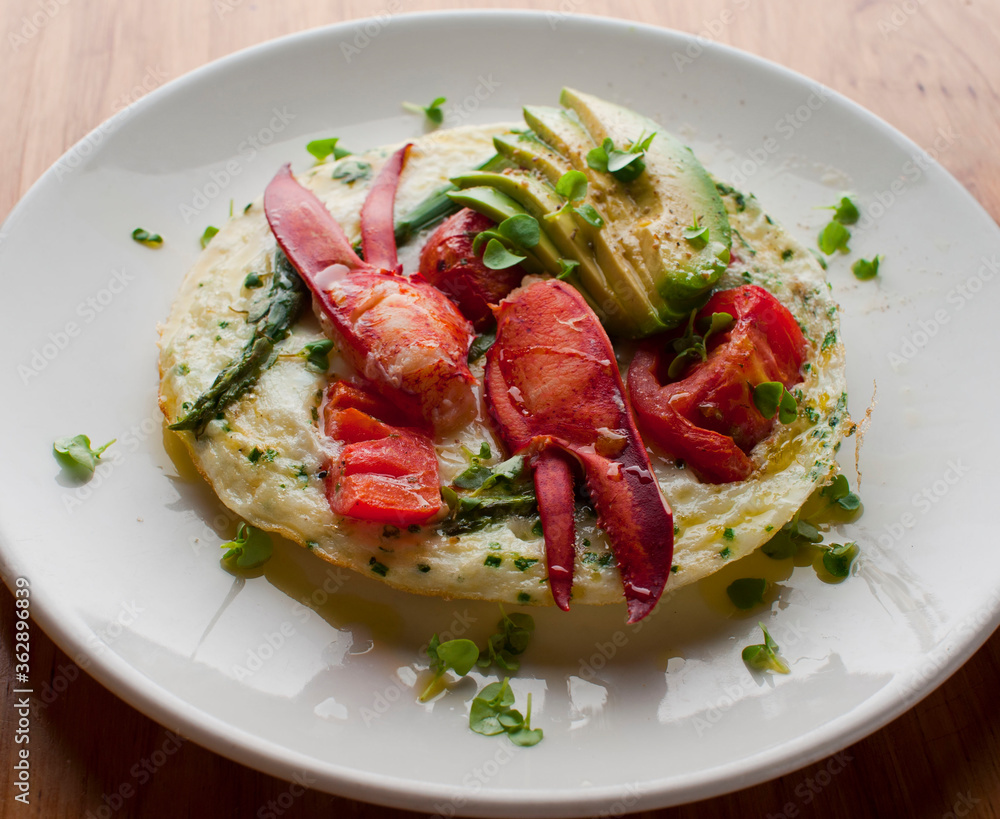 Frittata or omelette lobster avocado. Egg-based Italian dish w/ scrambled eggs, enriched with additional ingredients. classic seafood restaurant brunch/breakfast menu item. Maine lobster frittata. 