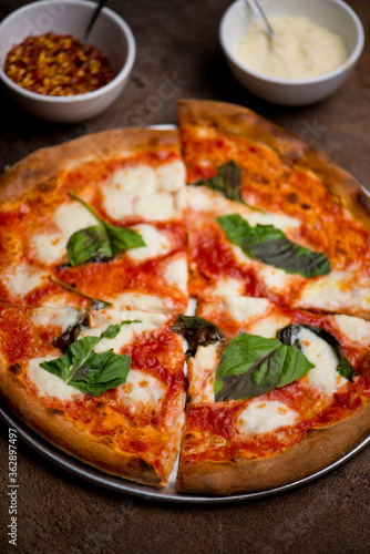 Pizza. Traditional New York City style margarita pizza pie with a thin homemade crispy crust  fresh tomato garlic marinara sauce topped with buffalo mozzarella cheese and fresh basil leaves.