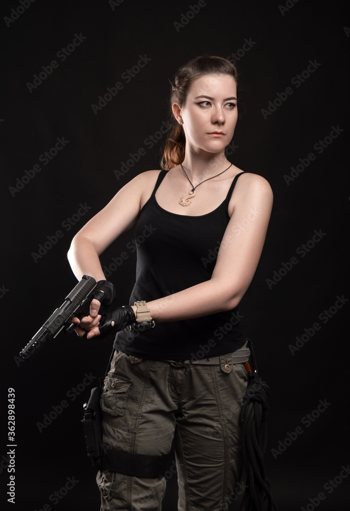 a Girl with a view to the knee is holding a gun with both hands