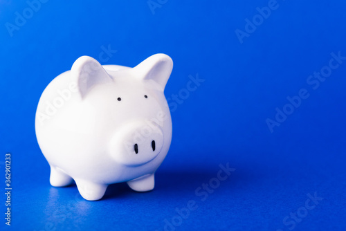 Front small white fat piggy bank, studio shot isolated on dark blue background and copy space for use, Finance, deposit saving money concept © sorapop