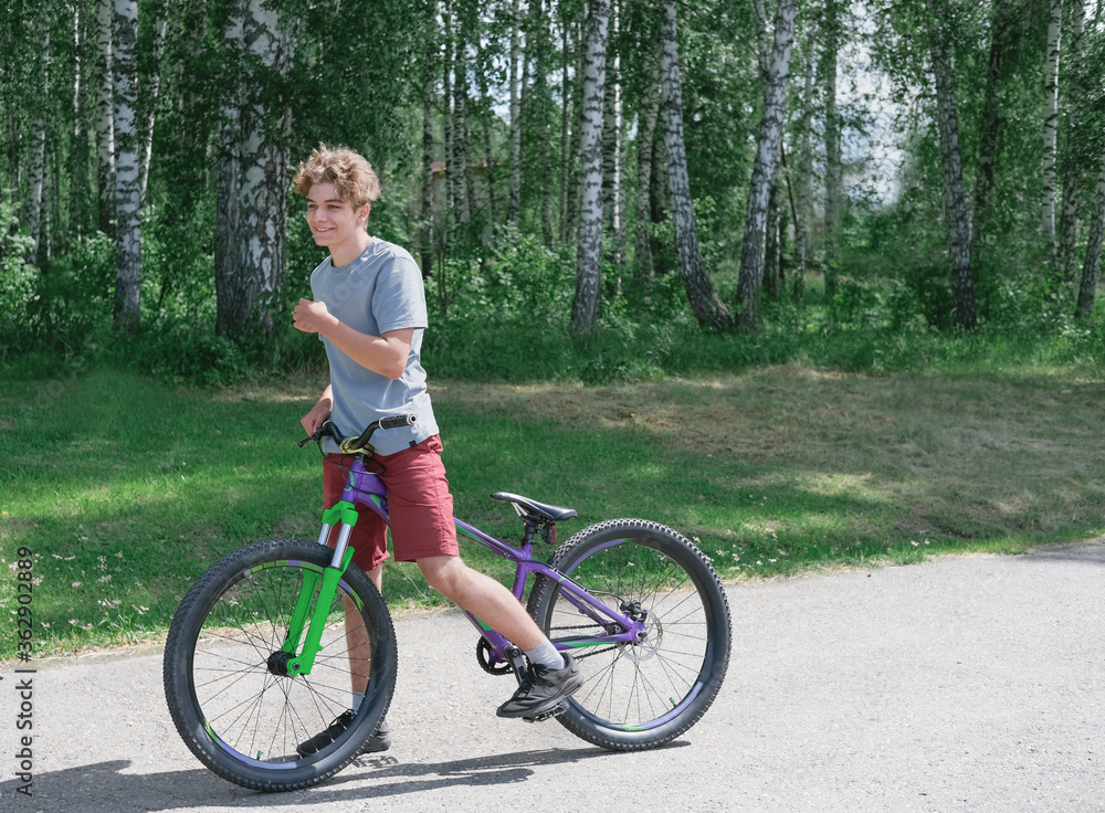 happy smiling teenager boy on a bicycle. summer activity and outdoors activity concept. healthy lifestyle. teenagers leisure. BMX rider guy. happy smiling teenager boy on a bicycle. summer activity and outdoors activity concept. healthy lifestyle. teenagers leisure. BMX rider guy.