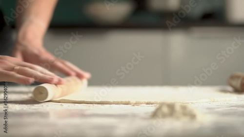 Man cooks pizza. Prepering ingredients for pizza.Roll out the dough with a rolling pin photo