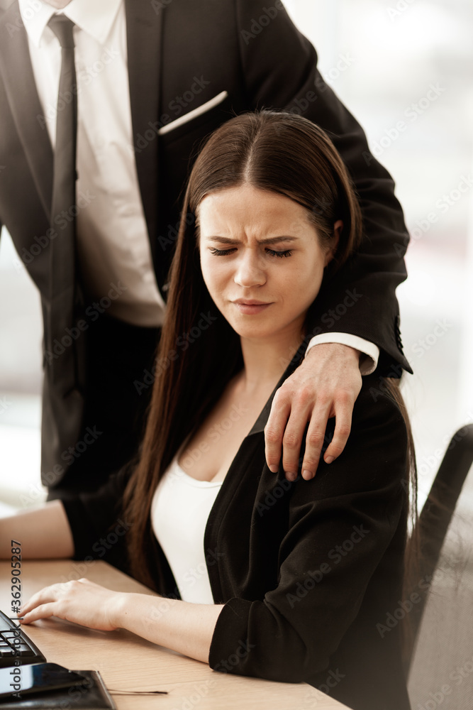 Sexual harassment at work. Male businessman puts hand on annoyed female ...