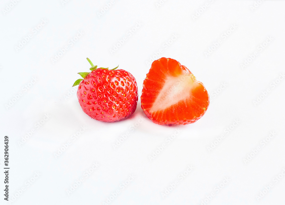 Ripe whole and half strawberries isolated on a white background Ripe whole and half strawberries isolated on a white background
