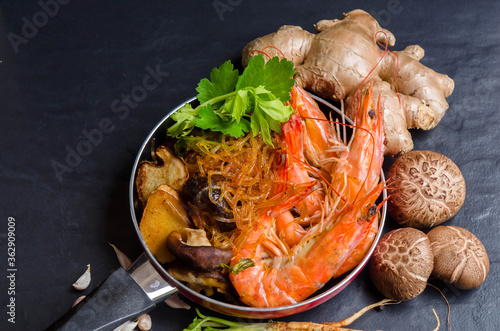 Casseroled Shrimp with vermicelli,Casseroled shrimps with glass noodles,Baked shrimp vermicelli,shrimps potted with vermicelli "Kung Ob Woon-Sen" on black background with ingredients 