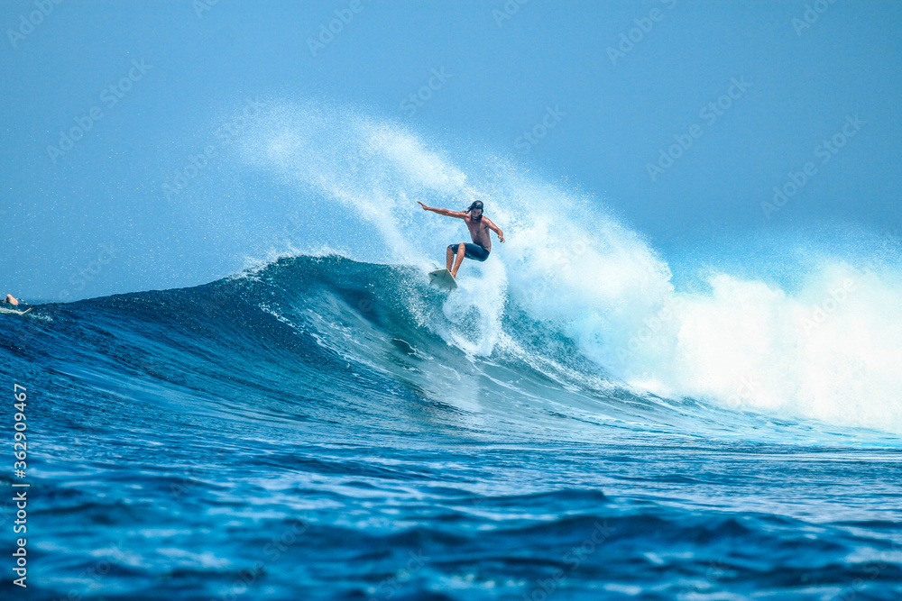 Surfer on perfect blue aquamarine wave, empty line up, perfect for surfing, clean water, Indian Ocean . - obrazy, fototapety, plakaty 