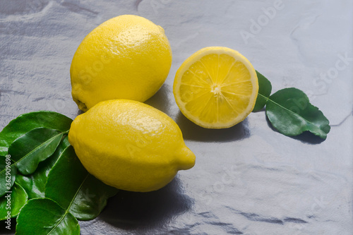 Fresh lemons on dark stone background