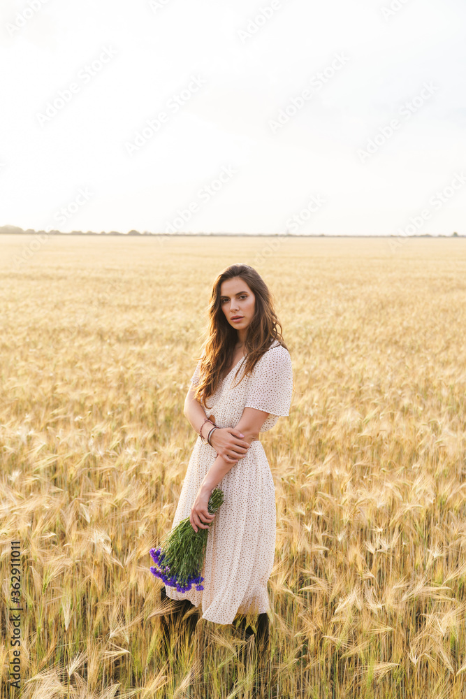 Photo of beautiful cute woman posing while walking on wheat field Photo of beautiful cute woman posing while walking on wheat field